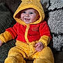 baby, child, couch, cozy, cute, face, happy, hoodie, indoor, infant, onesie, person, pillow, plush_clothing, red, seated, smile, soft_texture, winnie_the_pooh, yellow