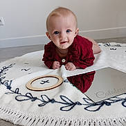 Cataleya a rejoint le concours — aidez-le/la à gagner de superbes lots ! baby, blanket, blue_eyes, child, curious, cute, embroidery, floor, fringe, happy, indoor, infant, mirror, portrait, red_clothing, reflection, smiling, soft_texture, tummy_time, wooden_frame