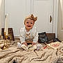 Cataleya participe au concours pour gagner de l'argent avec cette photo : baby, blanket, book, bow, candles, child, cozy, cute, decor, door, floor, golden_candle_holder, happy, headband, indoor, portrait, reading, sitting, smile, white_clothing