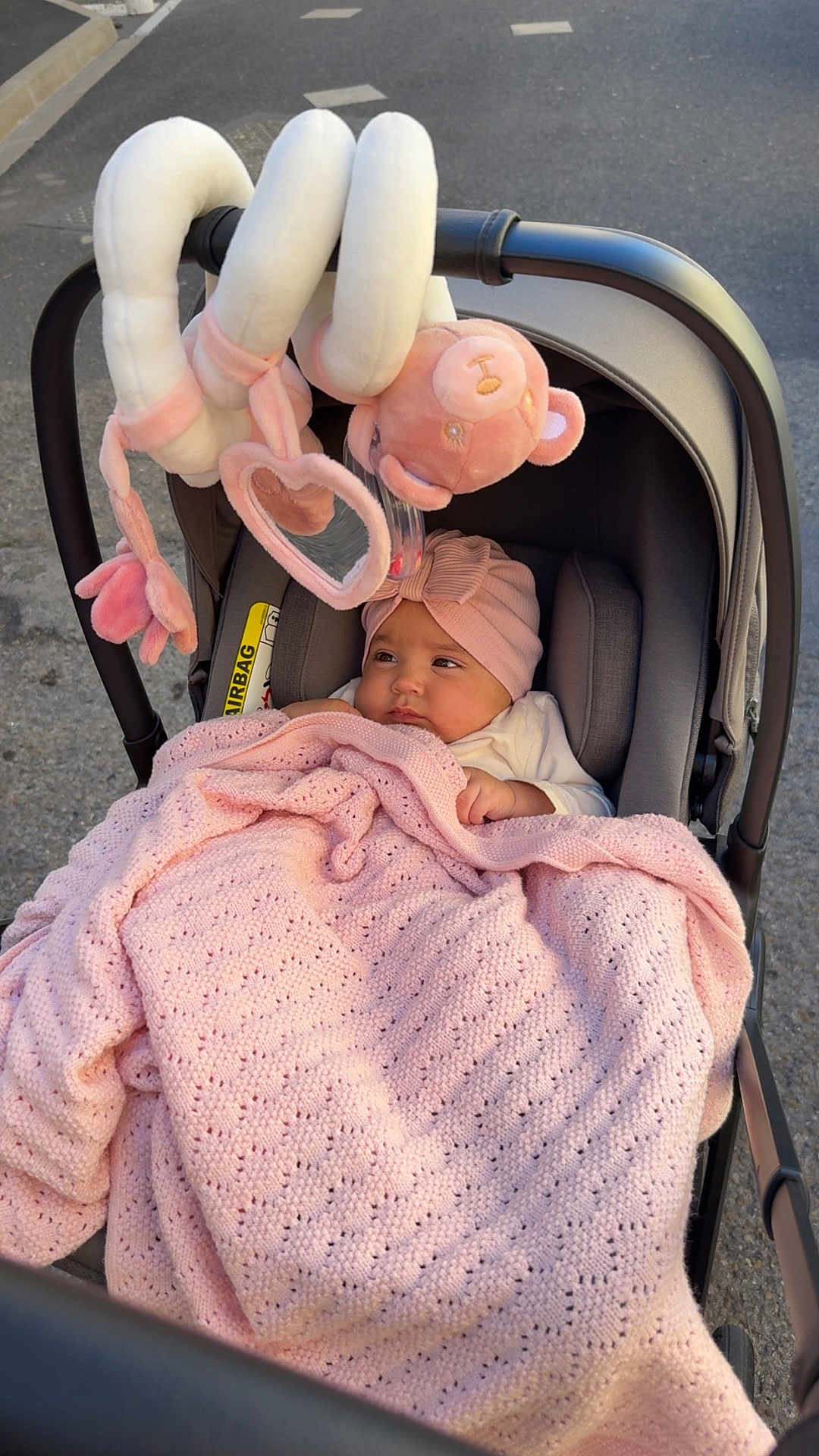 Ilyana a rejoint le concours — aidez-le/la à gagner de superbes lots ! baby, blanket, stroller, headband, plush_toy, mirror, outdoor, child, pink, cozy, infant, car_seat, soft, cute, toy, clothing, face, person, wrapped, relaxed