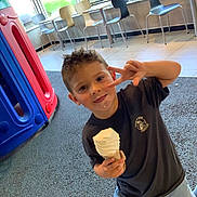 Brixton joined the competition — help win amazing prizes! child, boy, ice_cream, peace_sign, indoor, playground_equipment, chairs, smiling, shorts, tshirt, floor, window, daylight, happy, casual_clothing, fun, play, food, portrait, cute