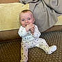 baby, blanket, blue_eyes, carpet, child, couch, cozy, cute, face, floor, hands, happy, home, indoor, infant, onesie, paw_prints, person, sitting, smiling