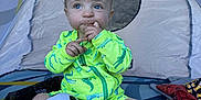Bryson is registered to the contest to win money with this photo: alligator_pattern, baby, blue_eyes, bright, child, colorful, curious, footwear_free, green_clothing, indoor, messy, playtime, sandy, short_hair, sitting, soccer_ball, teething_toy, tent, toddler, toy