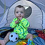 alligator_pattern, baby, blue_eyes, bright, child, colorful, curious, footwear_free, green_clothing, indoor, messy, playtime, sandy, short_hair, sitting, soccer_ball, teething_toy, tent, toddler, toy