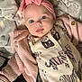adorable, animal_print, baby, blanket, blue_eyes, child, comfort, cozy, cute, headwear, indoors, infant, knit_sweater, laying_down, pink_headband, portrait, sleepwear, soft_texture, warm_clothing, young_child