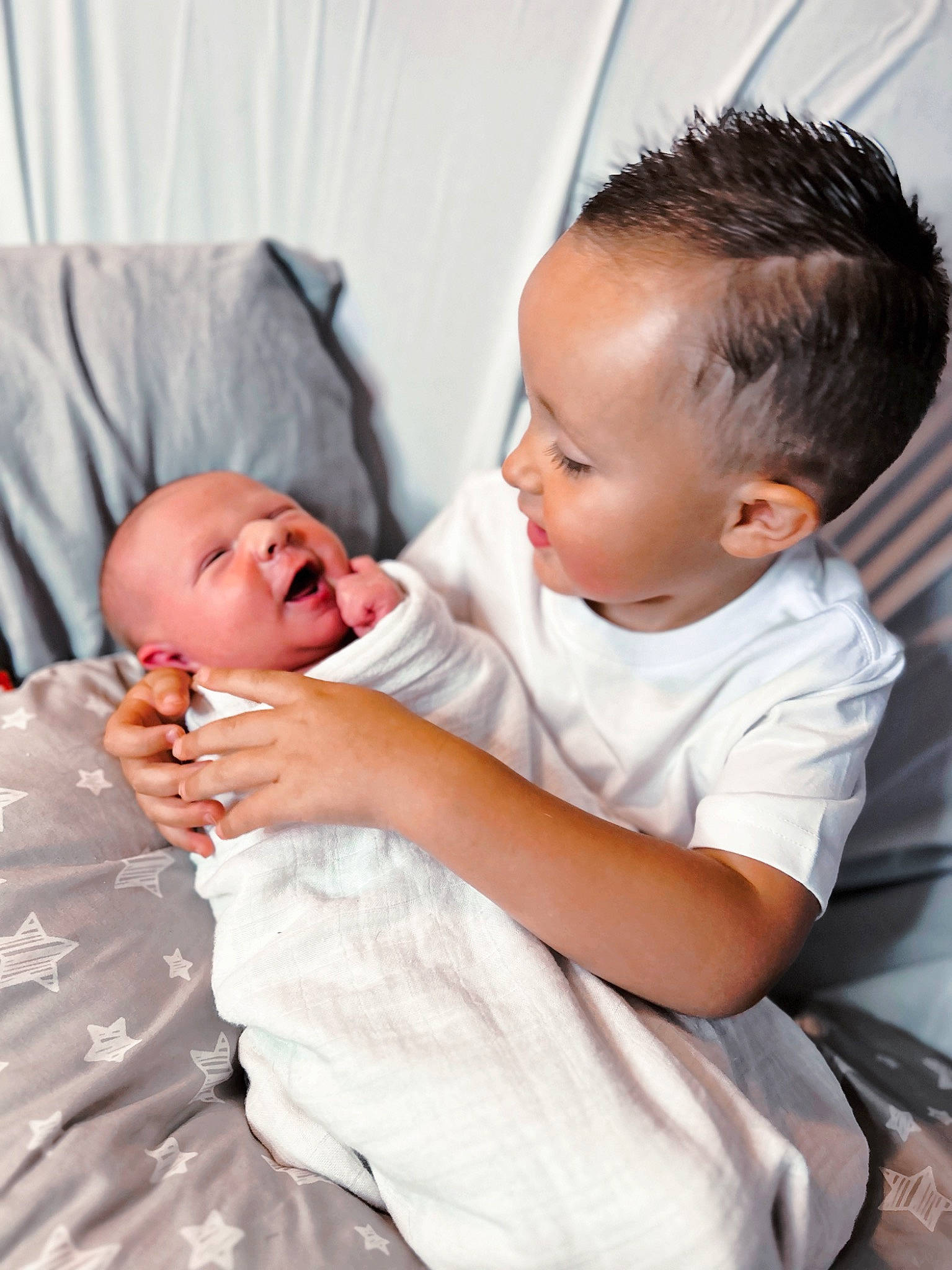 Kashton is registered to the contest to win money with this photo: abdomen, baby, baby_products, baby_toddler_clothing, chair, cheek, child, comfort, event, face, flash_photography, gesture, happy, nose, person, room, sitting, skin, smile, t_shirt