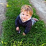 Esteban participe au concours pour gagner de l'argent avec cette photo : child, toddler, grass, outdoor, toy, motorcycle_toy, jacket, pants, smiling, happy, sunlight, nature, play, kneeling, young_child, daylight, casual_clothing, greenery, bare_hands, curly_hair