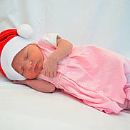 Lily joined the competition — help win amazing prizes! newborn, baby, sleeping, pink_clothing, santa_hat, infant, cute, holiday, soft, white_background, peaceful, portrait, lying_down, child, small, adorable, warm, resting, face, cozy
