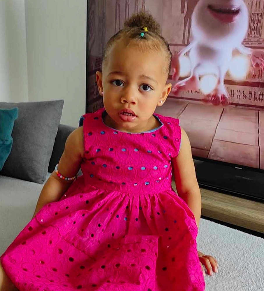 Yléana a rejoint le concours — aidez-le/la à gagner de superbes lots ! child, pink_dress, bracelet, living_room, couch, television, animated_character, curly_hair, earrings, expression, indoor, furniture, carpet, portrait, sitting, colorful, casual, cute, young, home