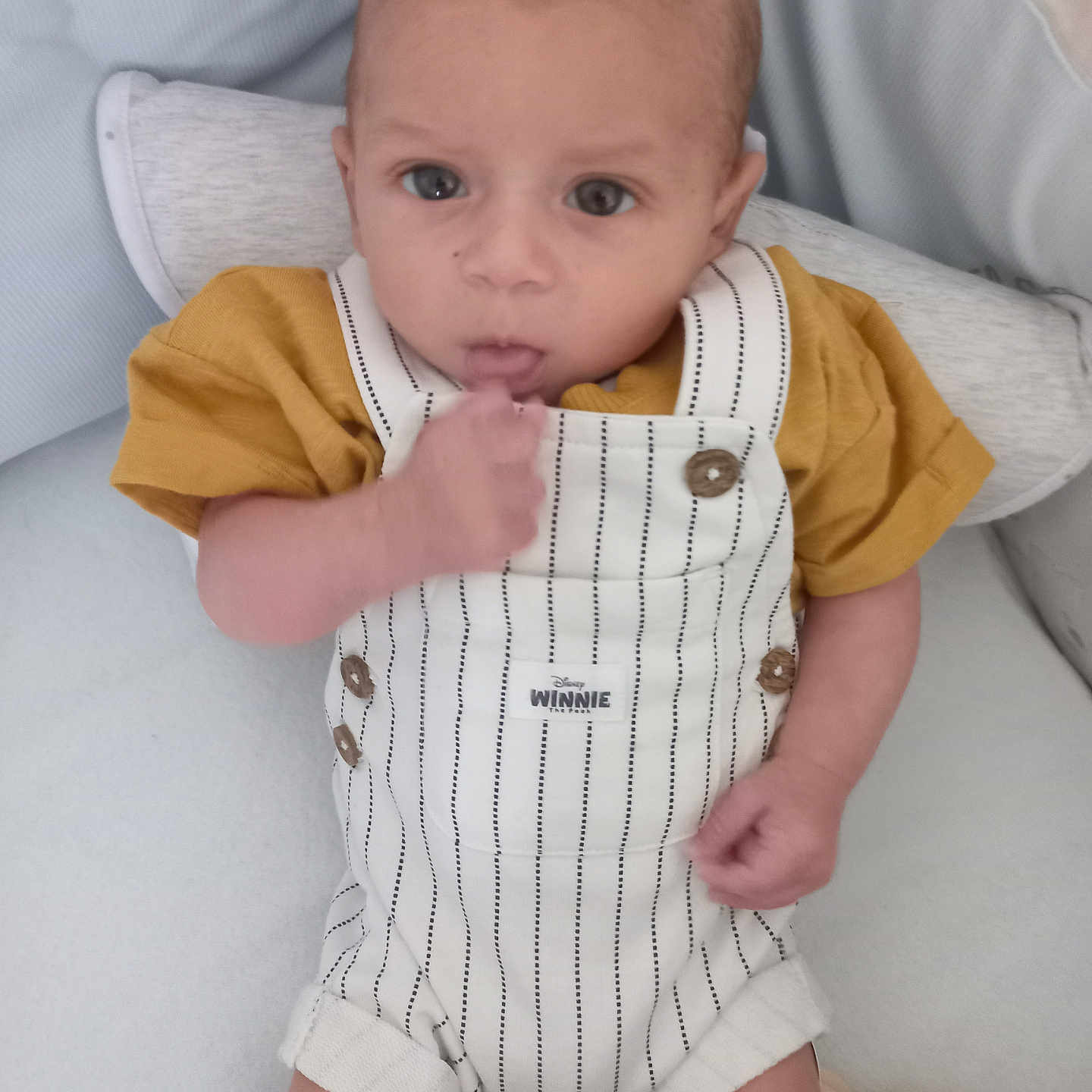 Nael a rejoint le concours — aidez-le/la à gagner de superbes lots ! baby, child, clothing, cushion, cute, elephant_toy, expression, face, hand, indoor, infant, pillow, plush_toy, portrait, sitting, soft_texture, striped_overalls, thumb_sucking, winnie_label, yellow_shirt