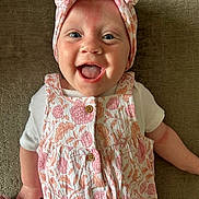 Penny joined the competition — help win amazing prizes! baby, infant, smiling, happy, face, headband, clothing, patterned, floral, cute, child, portrait, lying_down, skin, hand, white_shirt, button, fabric, texture, indoors