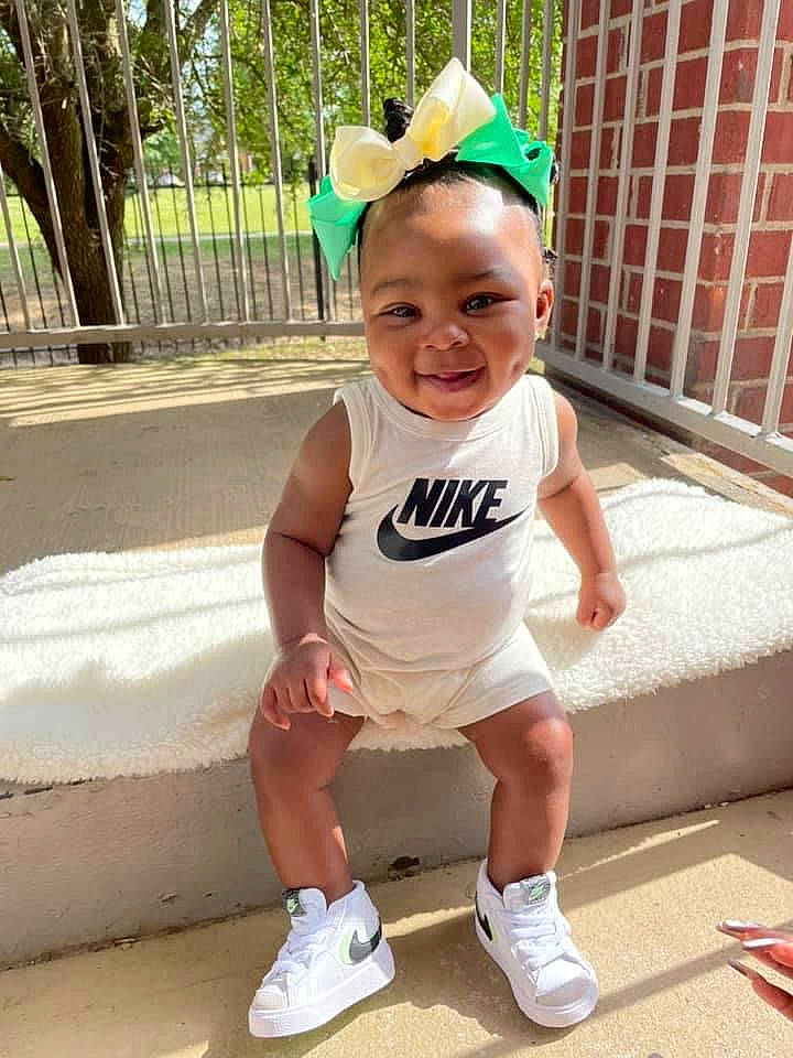 Klover is registered to the contest to win money with this photo: baby_toddler_clothing, cap, cool, fun, grass, hairstyle, happy, human_leg, joy, knee, leisure, person, pink, plant, public_space, recreation, shorts, sleeve, smile, thigh