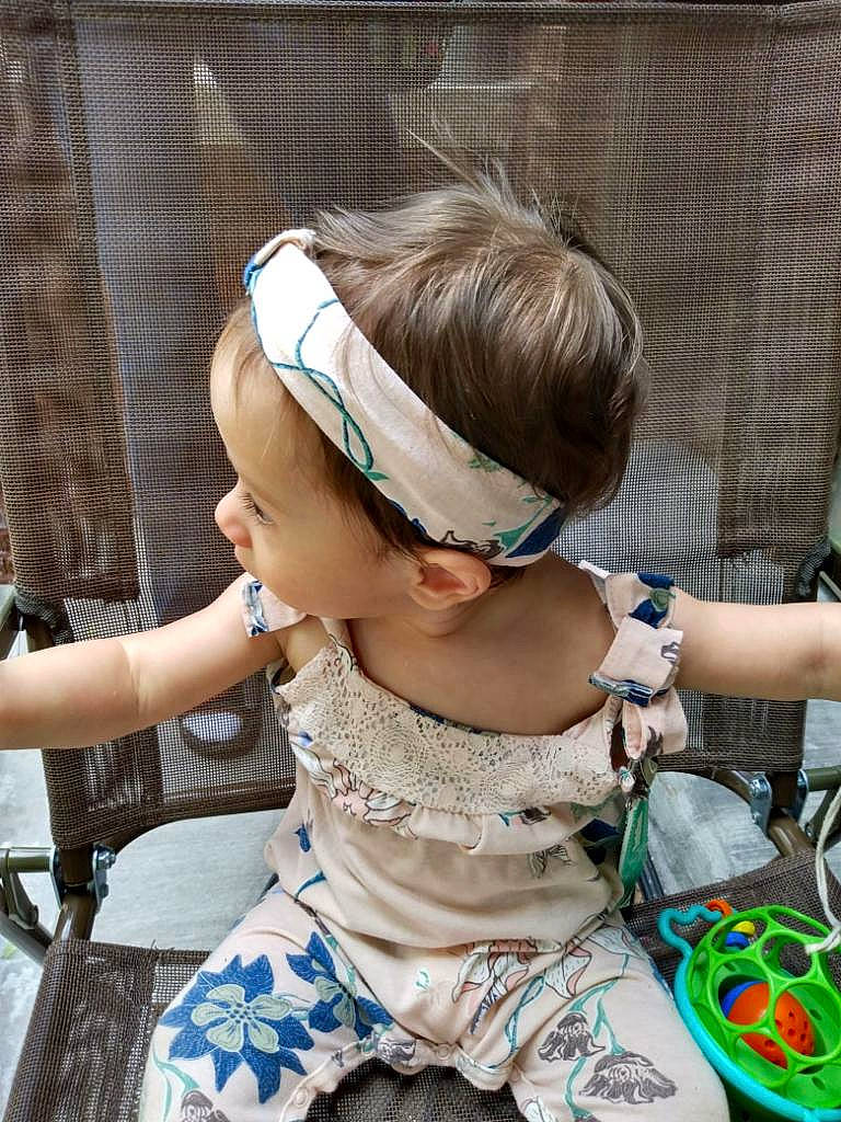 Renezmae is registered to the contest to win money with this photo: baby_toddler_clothing, blond, brown_hair, child, eyewear, fashion_accessory, fashion_design, glasses, goggles, grass, happy, headband, headpiece, jewellery, leisure, pattern, person, sitting, sunglasses, toddler