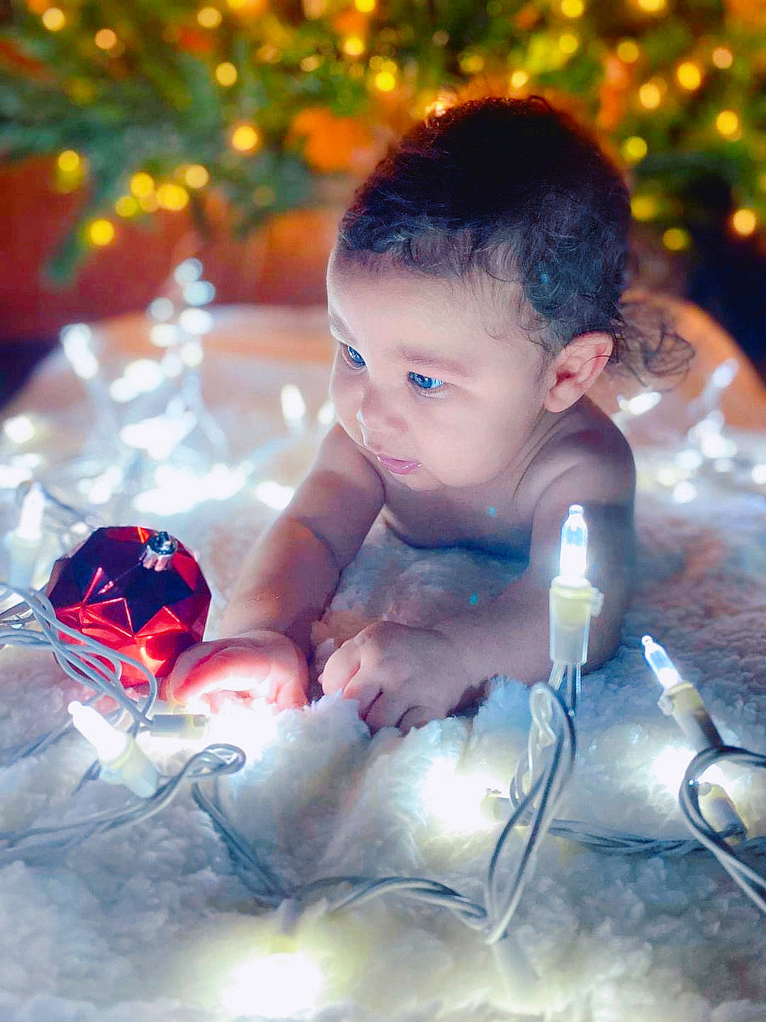 Levi is registered to the contest to win money with this photo: baby, child, christmas, christmas_decoration, christmas_ornament, facial_expression, finger, flash_photography, fun, happy, head, holiday, human, light, ornament, people, people_in_nature, person, plant, toddler