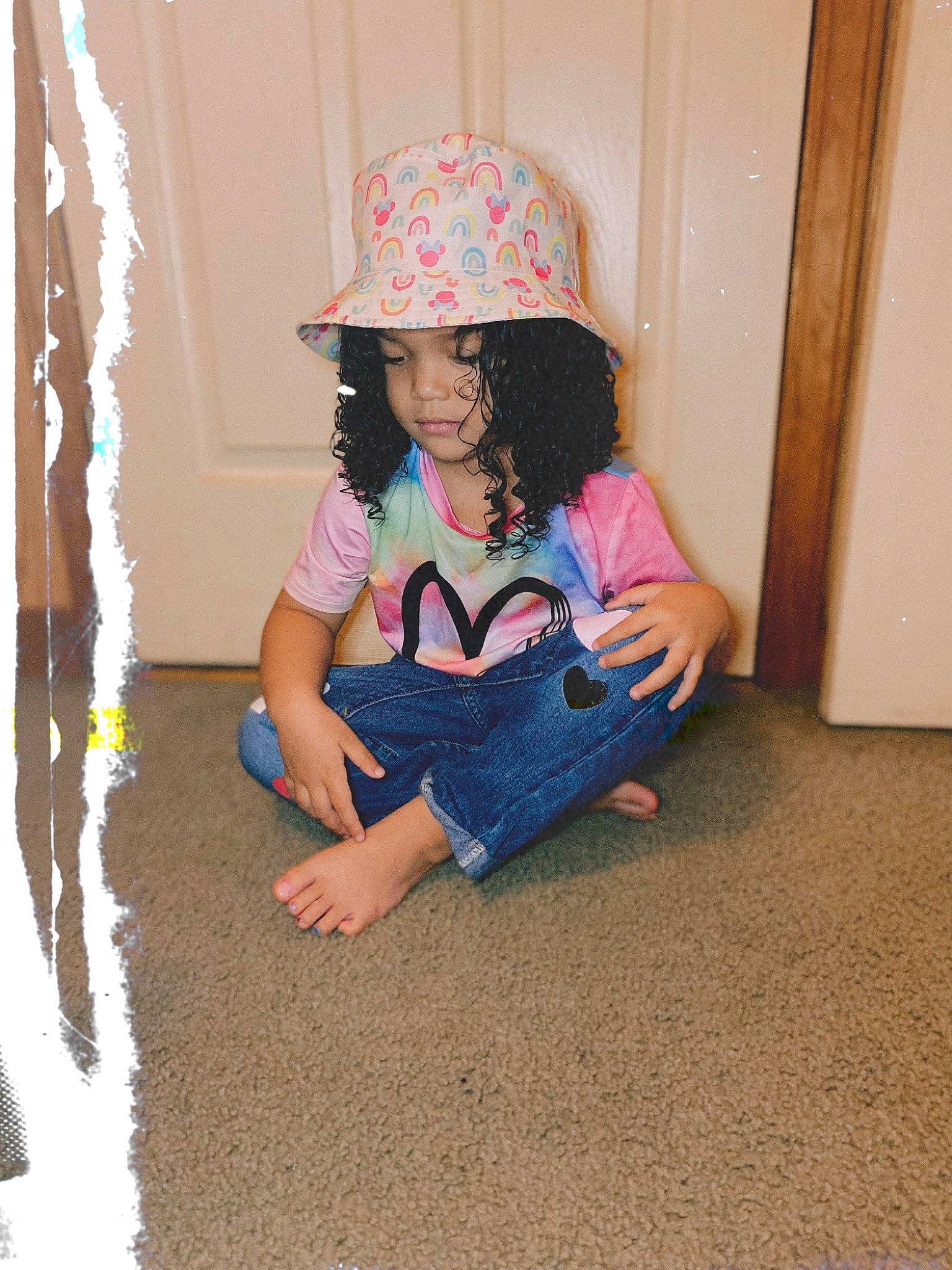 Xiomara is registered to the contest to win money with this photo: baby_toddler_clothing, barefoot, child, denim, electric_blue, facial_expression, floor, flooring, fun, happy, headwear, human_leg, jeans, knee, leisure, pattern, person, sitting, sleeve, thigh