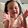 Mariana joined the competition — help win amazing prizes! toddler, child, clapping, smiling, happy, indoor, person, short_hair, hair_clip, pink_shirt, patterned_clothing, furniture, blanket, couch, face, motion_blur, cute, young_child, portrait, playful