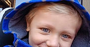 Grady is registered to the contest to win money with this photo: child, blue_eyes, hoodie, blue_hoodie, car_seat, seatbelt, smile, outdoor, sky, tree, young, face, portrait, casual_clothing, childhood, happy, person, closeup, daylight, blond_hair