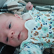 Arabella joined the competition — help win amazing prizes! baby, infant, newborn, onesie, floral_pattern, blanket, couch, face, eyes, hand, lying_down, portrait, closeup, skin, adorable, sleepy, clothing, soft_texture, home_interior, blanket_pattern