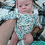 Arabella joined the competition — help win amazing prizes! baby, infant, newborn, onesie, floral_pattern, blanket, plaid, couch, arm, sock, legs, hand, face, portrait, indoor, cozy, soft_fabric, gaze, expression, person