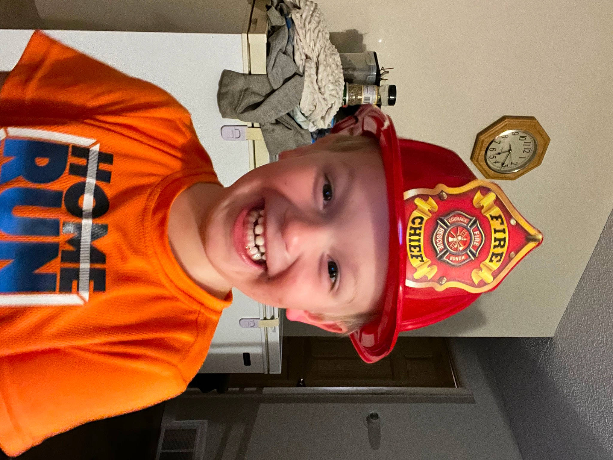 Jaxson is registered to the contest to win money with this photo: baseball_cap, cap, carmine, child, fashion_accessory, font, fun, happy, hat, headwear, joy, logo, orange, person, personal_protective_equipment, sleeve, smile, sports_jersey, t_shirt, toddler