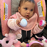 Jadeyn is registered to the contest to win money with this photo: baby, child, car_seat, pink_clothing, plush_toy, toy, infant, face, hand, earrings, seatbelt, blanket, indoor, cute, portrait, holding, playing, soft_toys, young_child, expression