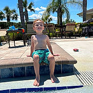 Legynd joined the competition — help win amazing prizes! child, boy, pool, swimming_trunks, water, sunny, outdoor, palm_trees, patio, chairs, smiling, happy, summer, daytime, barefoot, recreation, vacation, relaxing, blue_sky, holiday