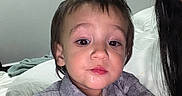 Khalid joined the competition — help win amazing prizes! child, toddler, portrait, face, indoor, bedroom, bed, pillow, blanket, adult, hand, ring, clothing, gray_shirt, dark_hair, brown_hair, sleepy, closeup, sitting, family