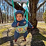baby, child, infant, swing, outdoor, park, tree, nature, winter_clothing, blue_jacket, hat, hood, boots, sitting, hanging, portrait, face, serious_expression, daylight, playground