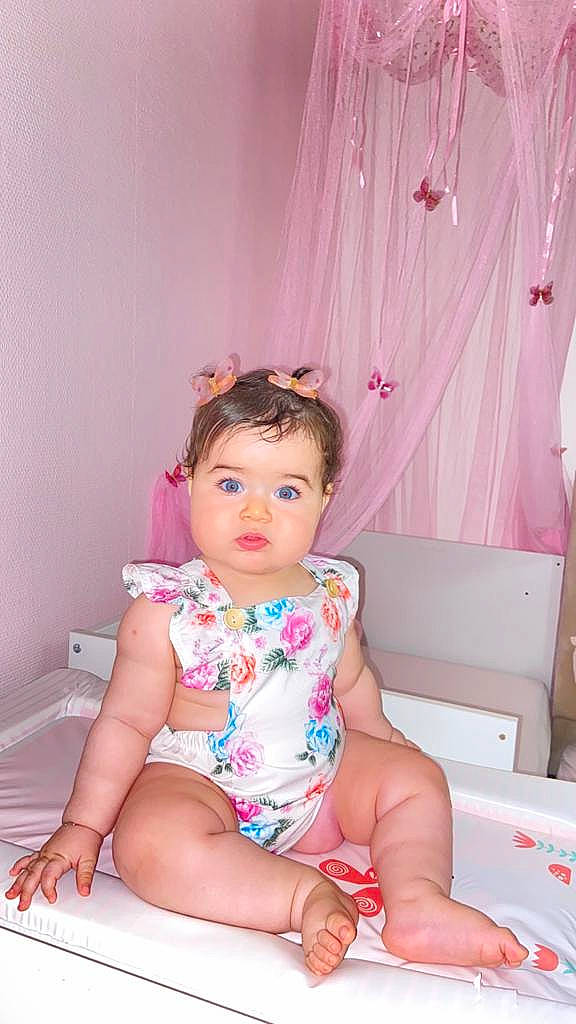Léa a rejoint le concours — aidez-le/la à gagner de superbes lots ! baby, baby_toddler_clothing, child, curtain, dress, foot, fun, happy, human_leg, leg, magenta, person, pink, purple, sitting, skin, sleeve, sock, textile, thigh