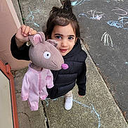 Chilo participe au concours pour gagner de l'argent avec cette photo : child, girl, plush_toy, mouse_puppet, chalk_drawings, sidewalk, outdoor, black_vest, white_sneakers, playtime, happy, cute, toy, pavement, casual_clothing, daylight, young_child, smiling, looking_up, hand_held_object