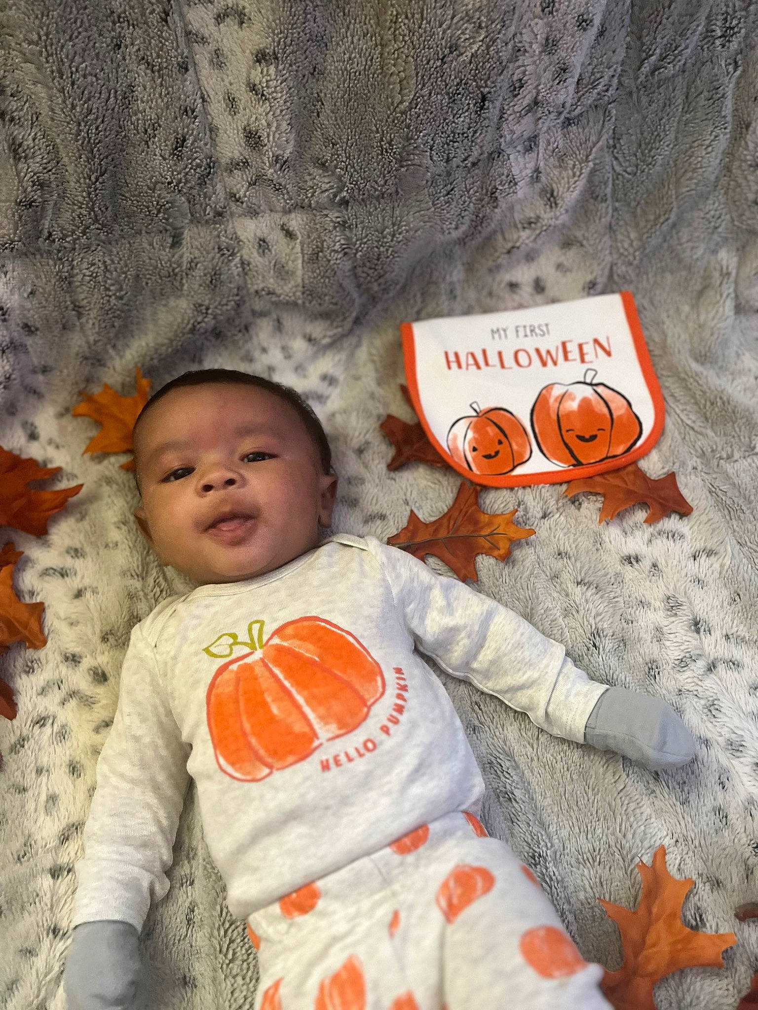 Kyree is registered to the contest to win money with this photo: baby, baby_toddler_clothing, child, eye, flooring, font, fur, happy, linens, logo, orange, pattern, people_in_nature, person, room, sitting, sleeve, smile, toddler, white