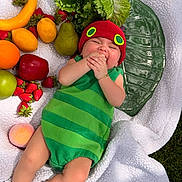 Valentina joined the competition — help win amazing prizes! apple, baby, banana, blanket, caterpillar_costume, child, cute, fruit, grass, green_outfit, infant, lettuce, lying_down, orange, outdoor, pear, playful, red_hat, smiling, strawberry