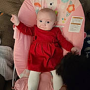 Rylee is registered to the contest to win money with this photo: animal, baby, child, couch, cozy, curious, cute, dog, furniture, home, indoor, infant, interaction, person, pet, pink_baby_seat, red_dress, unicorn, white_tights, wide_eyes