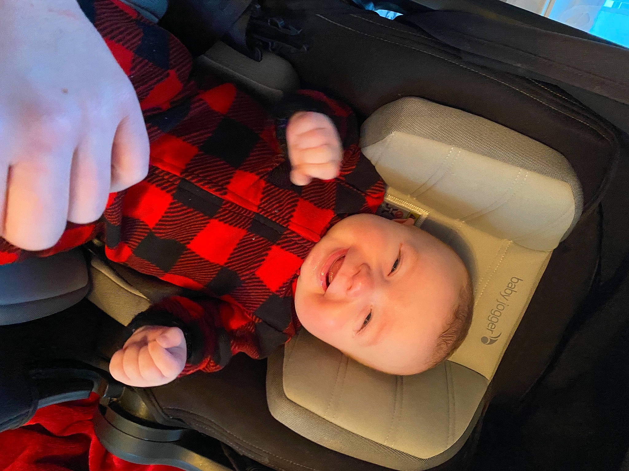 Casey is registered to the contest to win money with this photo: automotive_design, automotive_lighting, automotive_tire, baby_carriage, car_seat, finger, fun, gesture, hand, human_body, leg, mouth, person, plaid, product, skin, smile, tartan, thumb, toddler