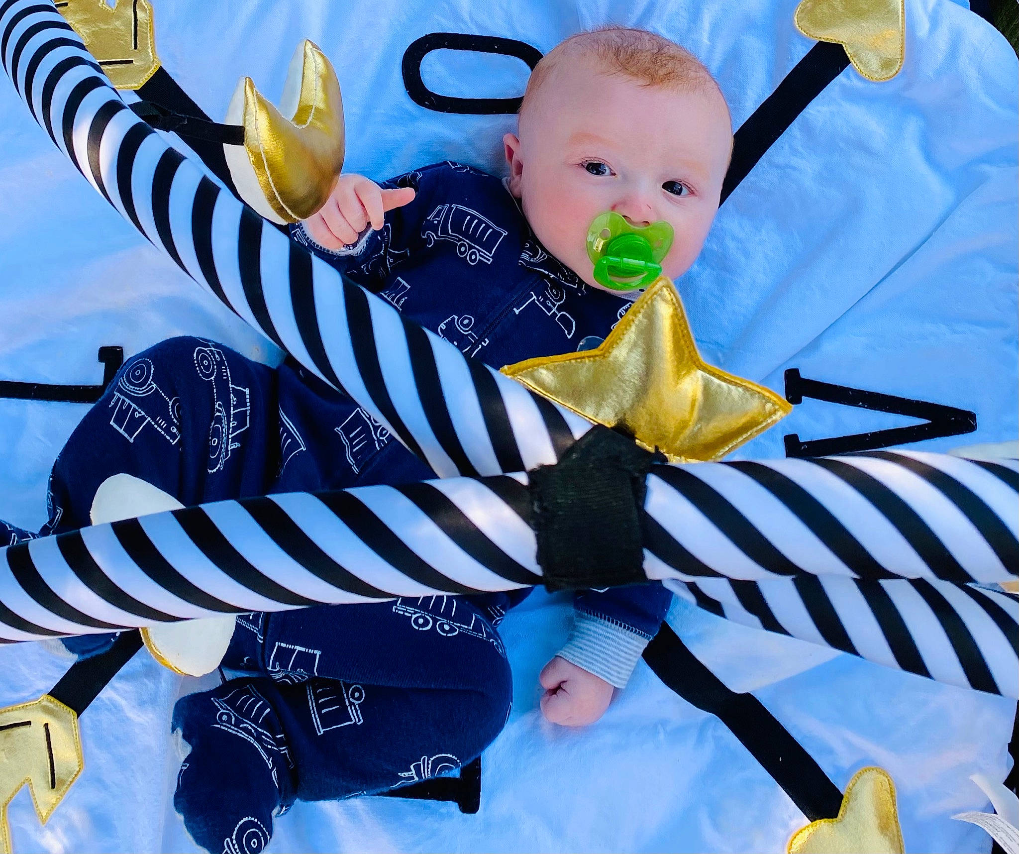 Casey is registered to the contest to win money with this photo: baby, baby_products, baby_safety, baby_toddler_clothing, electric_blue, event, font, graphics, green, happy, pattern, people_in_nature, person, sitting, sleeve, toddler, white