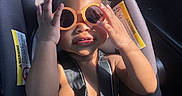 Fasha Douglas joined the competition — help win amazing prizes! toddler, child, sunglasses, car_seat, seatbelt, sunlight, car_interior, black_hair, summer, cute, baby, portrait, sitting, playful, orange_sunglasses, safety, seat, vehicle, happy, skin