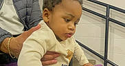 Fasha Douglas joined the competition — help win amazing prizes! toddler, child, adult, stadium_seat, purple_seat, indoor, railing, person, curious, pigtails, jacket, sunglasses, supporting, people, sports_venue, concrete_floor, white_wall, hand, casual_clothing, event