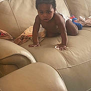 Fasha Douglas is registered to the contest to win money with this photo: toddler, child, crawling, diaper, couch, leather, indoor, baby, blanket, toy, furniture, person, home, curious, hair, skin, young, seat, living_room, casual
