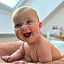 Lyana participe au concours pour gagner de l'argent avec cette photo : baby, infant, smiling, laughing, blue_eyes, chubby_cheeks, close_up, portrait, tummy_time, diaper, bare_skin, happy, mouth_open, cute, indoor, natural_light, window, cushion, soft_blanket, nursery_background