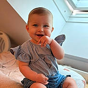 Lyana a rejoint le concours — aidez-le/la à gagner de superbes lots ! baby, infant, smiling, blue_eyes, dress, indoor, window, natural_light, portrait, cute, sitting, chubby_cheeks, hand, blanket, bedding, leg, short_hair, skylight, toddler, happy