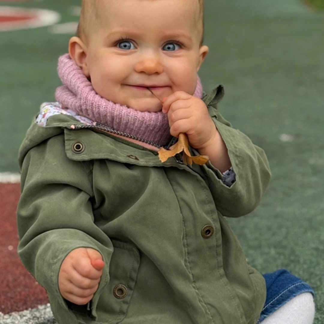 Lyana a rejoint le concours — aidez-le/la à gagner de superbes lots ! baby, blue_eyes, bokeh, child, cute, denim_shorts, face, grass, hand, jacket, knit_scarf, leaf, outdoors, playground, portrait, shoe, sitting, smile, tights, toddler