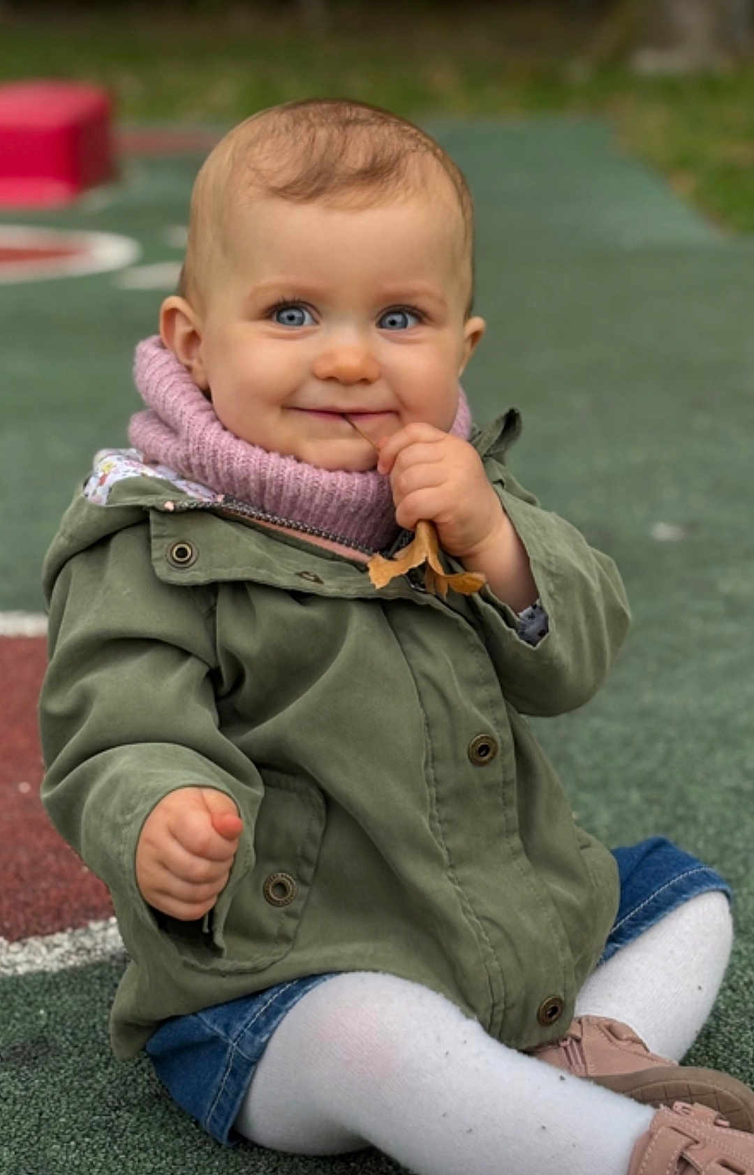 Lyana a rejoint le concours — aidez-le/la à gagner de superbes lots ! baby, toddler, child, face, blue_eyes, smile, jacket, knit_scarf, leaf, sitting, playground, shoe, tights, denim_shorts, hand, portrait, outdoors, bokeh, grass, cute