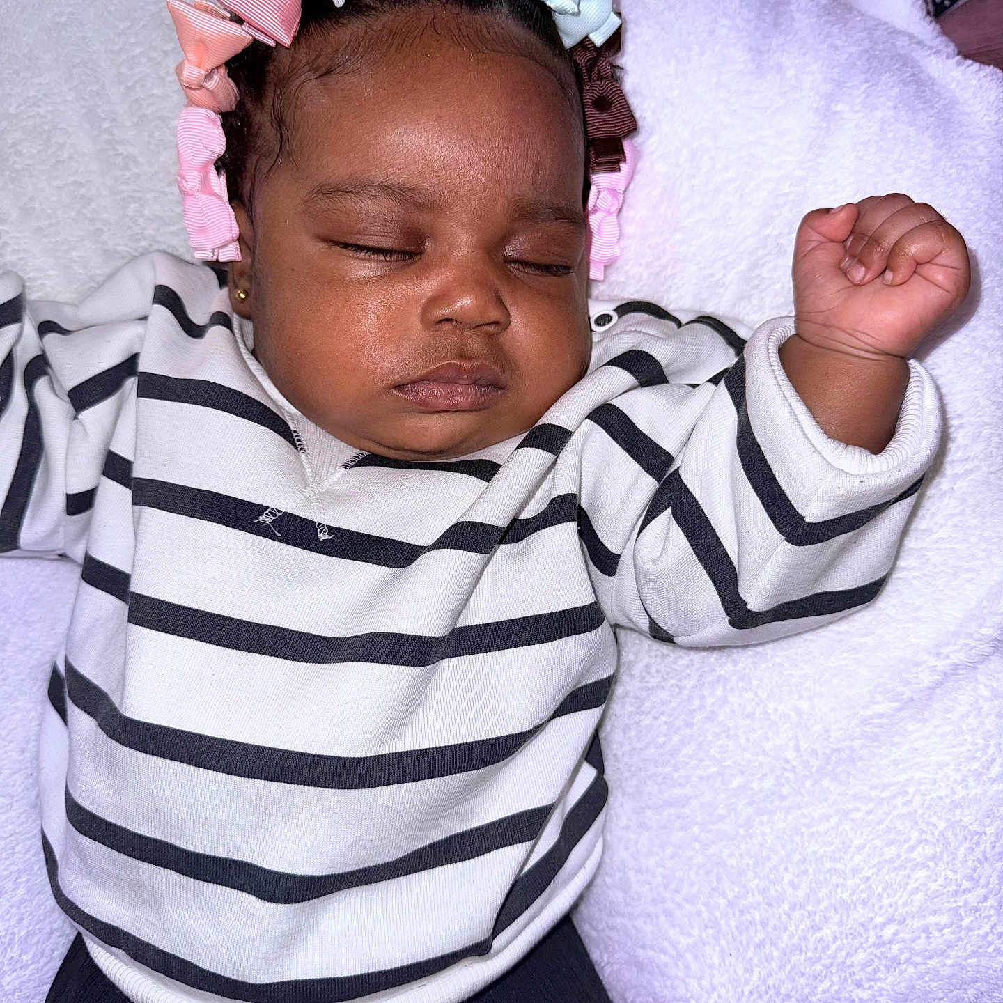 Maryam joined the competition — help win amazing prizes! baby, bows, child, closeup, cozy, cute, face, hair_accessories, hand, indoor, infant, peaceful, person, portrait, relaxation, resting, sleeping, soft_texture, striped_sweater, white_blanket