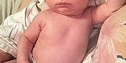 Tesssa joined the competition — help win amazing prizes! baby, infant, diaper, person, skin, hand, arm, face, hair, eyes, bed, blanket, adult, lap, human, newborn, cute, expression, indoors, sleepwear