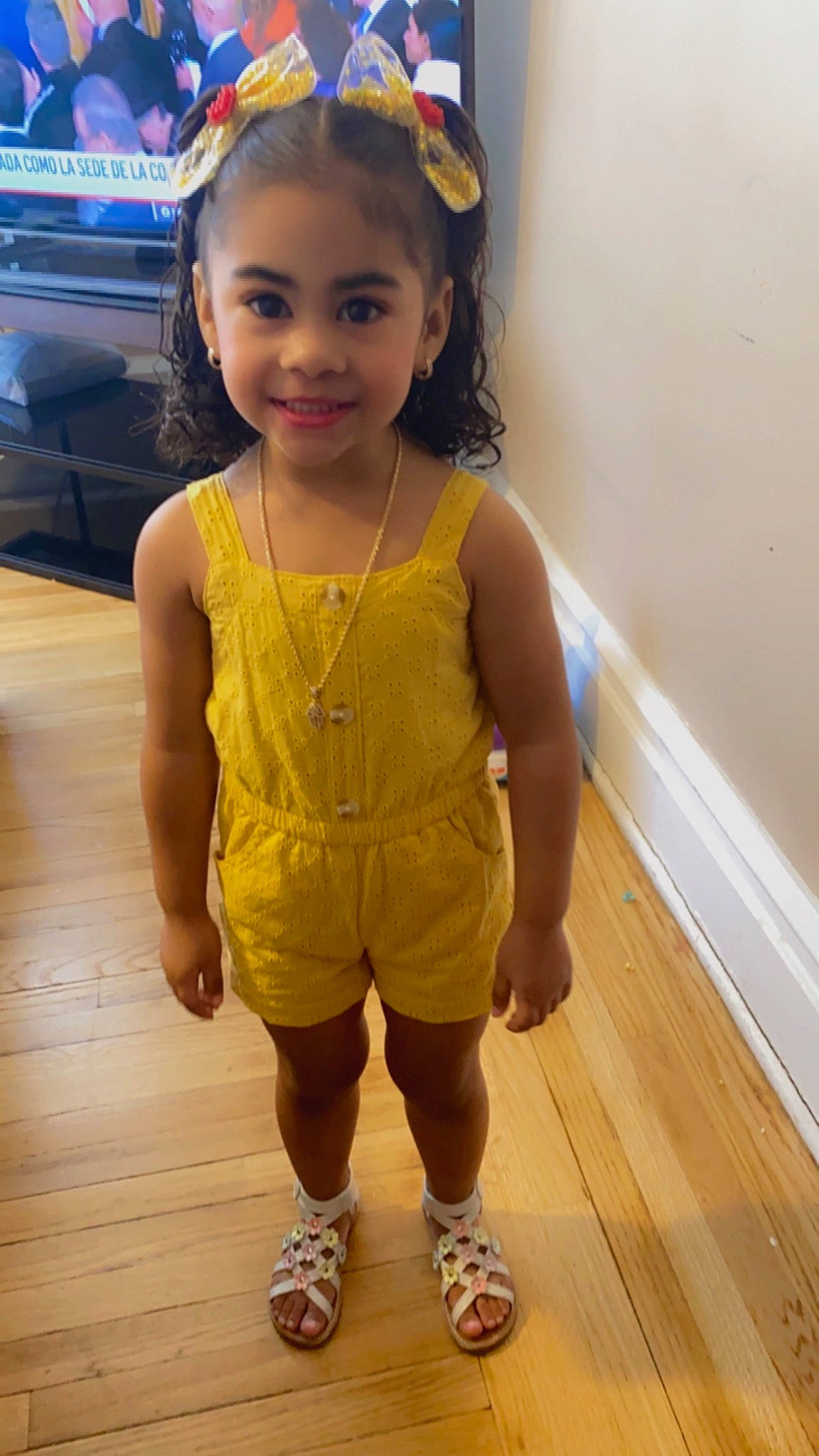 Naelisha joined the competition — help win amazing prizes! baby_toddler_clothing, eye, face, flooring, fun, hair, hairstyle, happy, hardwood, iris, joy, long_hair, person, skin, sleeve, smile, standing, television, thigh, toddler