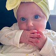Flo joined the competition — help win amazing prizes! baby, infant, child, headband, yellow_bow, hands, fingers, sucking, white_outfit, duck_pattern, close_up, face, eyes, curious, sitting, chair, window, natural_light, indoor, portrait