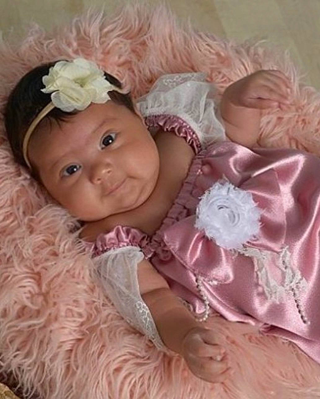 Alani is registered to the contest to win money with this photo: baby, baby_toddler_clothing, cheek, child, embellishment, eye, flower, hair_accessory, happy, head, headgear, headpiece, headwear, iris, magenta, person, petal, pink, skin, smile