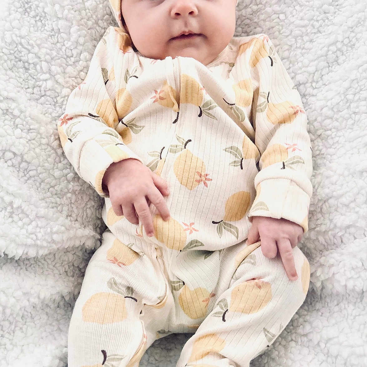 Presley is registered to the contest to win money with this photo: baby, blanket, child, closeup, cozy, cute, expression, face, feet, hands, headband, indoor, infant, laying_down, newborn, onesie, patterned_clothing, portrait, sleepwear, soft_texture