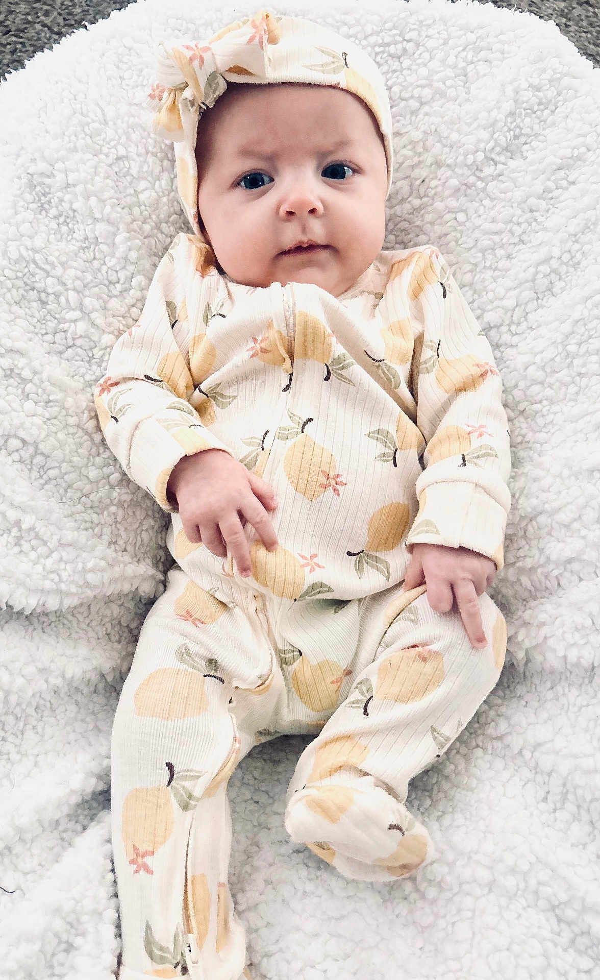 Presley is registered to the contest to win money with this photo: baby, infant, onesie, headband, blanket, patterned_clothing, portrait, indoor, cute, child, newborn, soft_texture, cozy, sleepwear, face, expression, hands, feet, laying_down, closeup