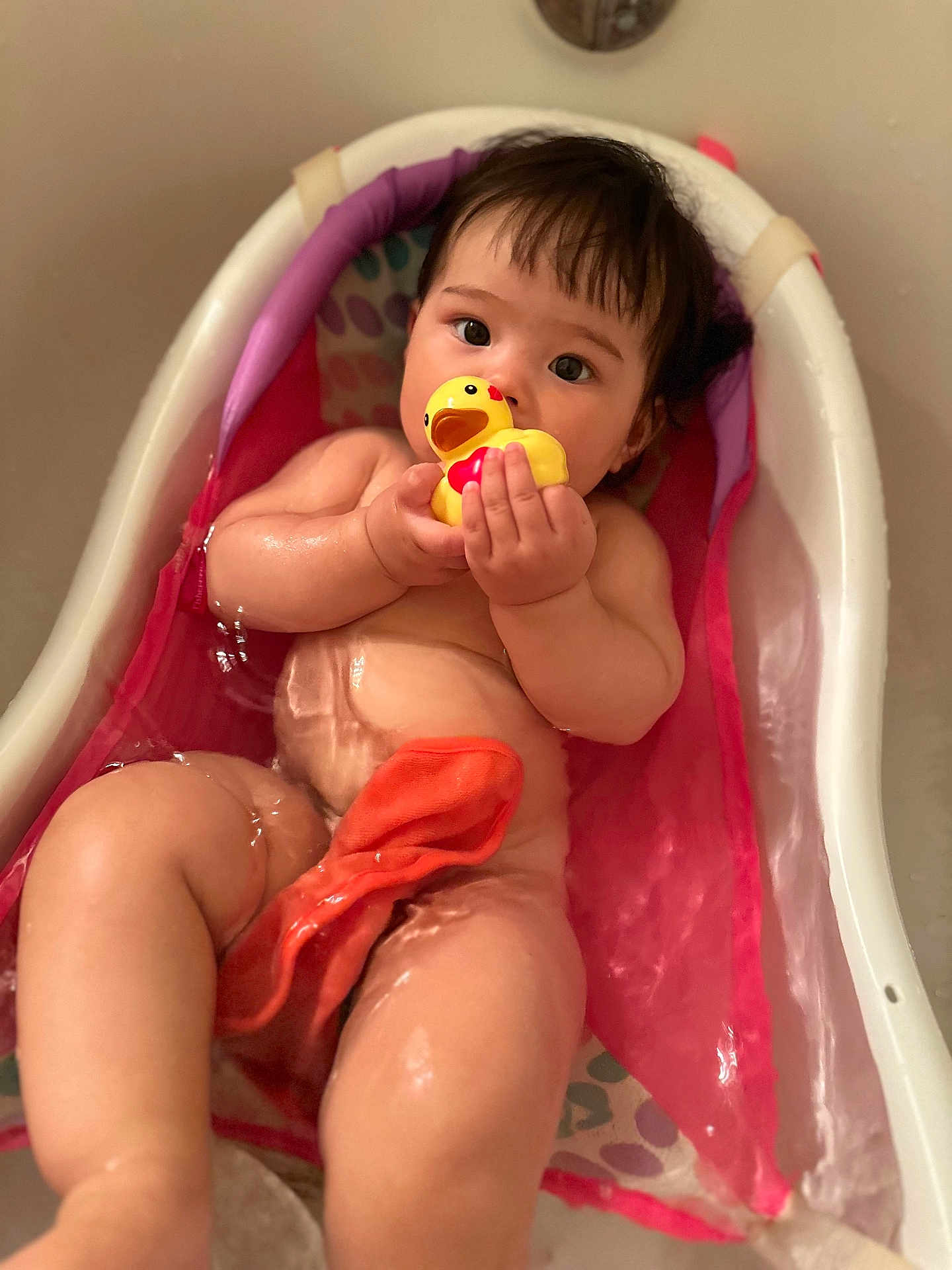 Rei is registered to the contest to win money with this photo: baby, bathtub, water, rubber_duck, child, skin, bath_time, toddler, toy, naked, cute, indoors, infant, pink, colorful, relaxing, sitting, small_bathtub, playful, wet